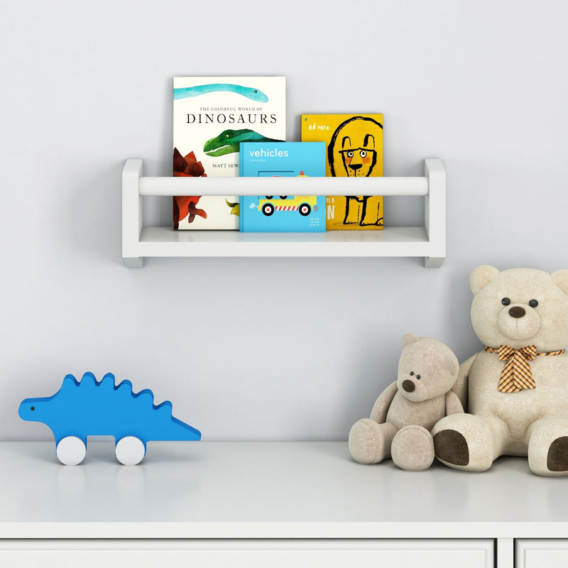 Children's room bookshelf with picture books, stuffed teddy bears, and a blue dinosaur toy on a white shelf.