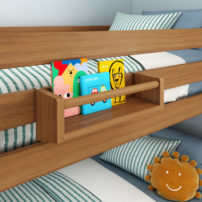 Children's bed with a wooden safety rail bookshelf and colorful books, featuring striped bedding and a smiling sun pillow.