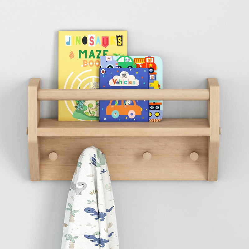 Wooden wall shelf with children's books and dinosaur-themed towel hanging.