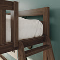 Close-up of dark walnut bunk bed ladder and guardrail showing wood grain, white bedding and teal bedroom wall
