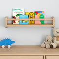 Kids' books displayed on a wooden wall shelf next to teddy bears in a nursery room.