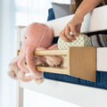 Child's hand placing toy on bunk bed shelf with stuffed pink octopus, promoting kids' room organization and decor ideas.