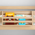 Light wood toddler bunk bed safety rail with built-in book pocket holding colorful children's books and vehicle board book