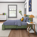 Kids bedroom decor with green upholstered bed, blue gingham bedding, orange bedside lamp, space poster, pennant and soccer ball