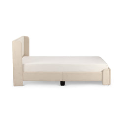 Beige upholstered platform bed frame with tall padded headboard and white mattress, modern minimalist bedroom furniture, side view