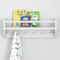 Child's bookshelf with dinosaur and vehicle-themed books and hanging dinosaur-patterned towel.