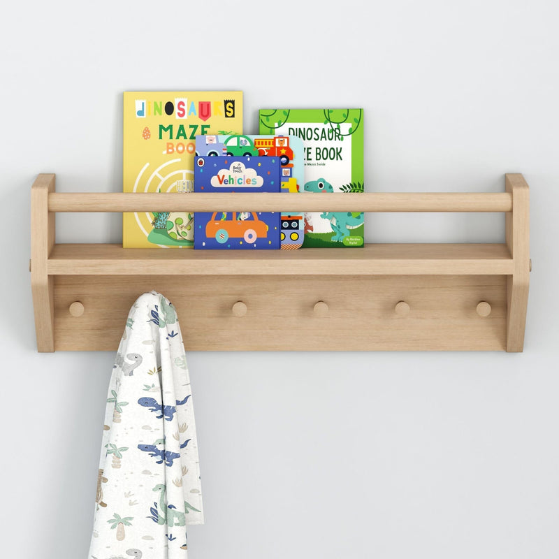 Wooden wall shelf with children's dinosaur books and a hanging towel.