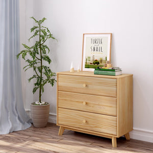 Light wooden dresser with potted indoor plant, framed turtle and snail print, children's books — minimalist nursery decor