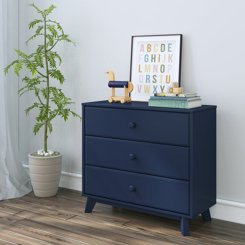 Dark blue modern dresser with alphabet decor and potted plant on wooden floor.
