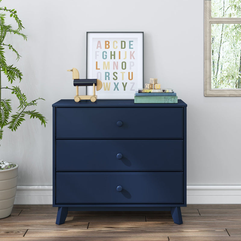Navy blue three-drawer dresser in nursery with framed colorful alphabet print, wooden toy horse, stacking blocks and potted plant