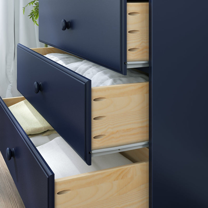 Modern navy blue dresser with round knobs and three open natural wood drawers neatly storing folded white and beige linens in a bedroom