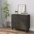 Mid-century dark gray three-drawer wooden dresser in nursery with colorful framed alphabet print, wooden toy horse, stacked books and potted plant
