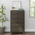 Tall five-drawer dark gray wooden dresser chest of drawers styled in a modern nursery or bedroom with a framed colorful alphabet print, wooden toy horse, stacked books and potted plant