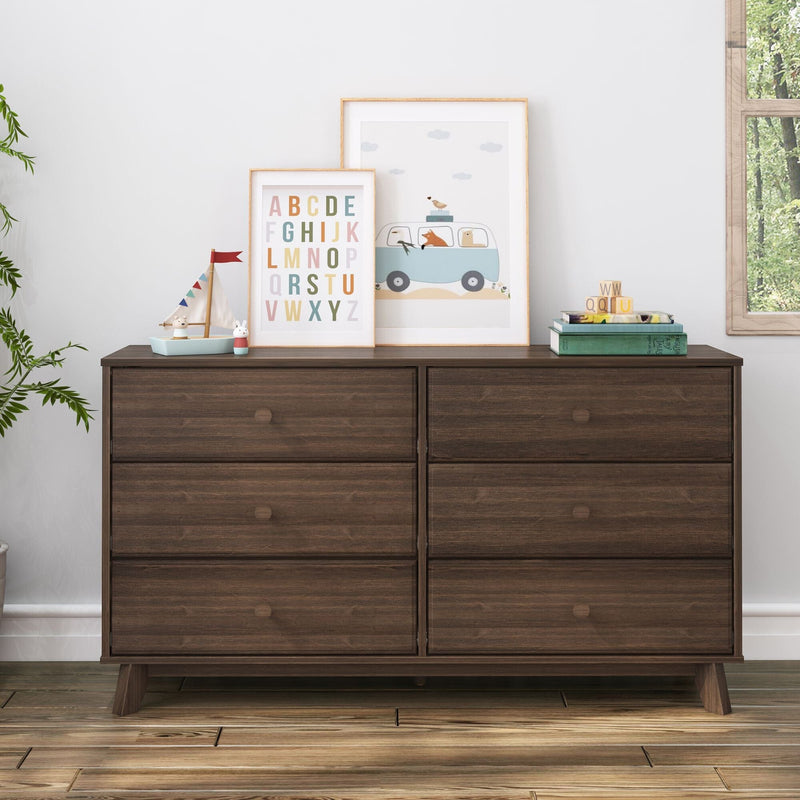 Modern dark wood dresser with alphabet decor and children's artwork.