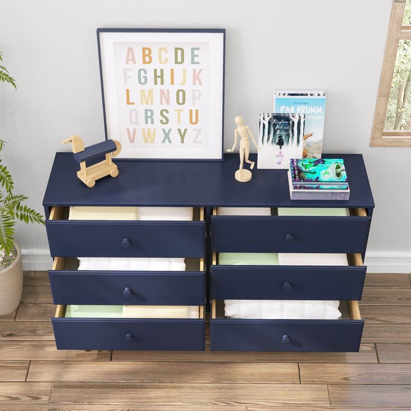 Navy blue six-drawer dresser for kids' room with open drawers, alphabet wall art, wooden toy and children's books