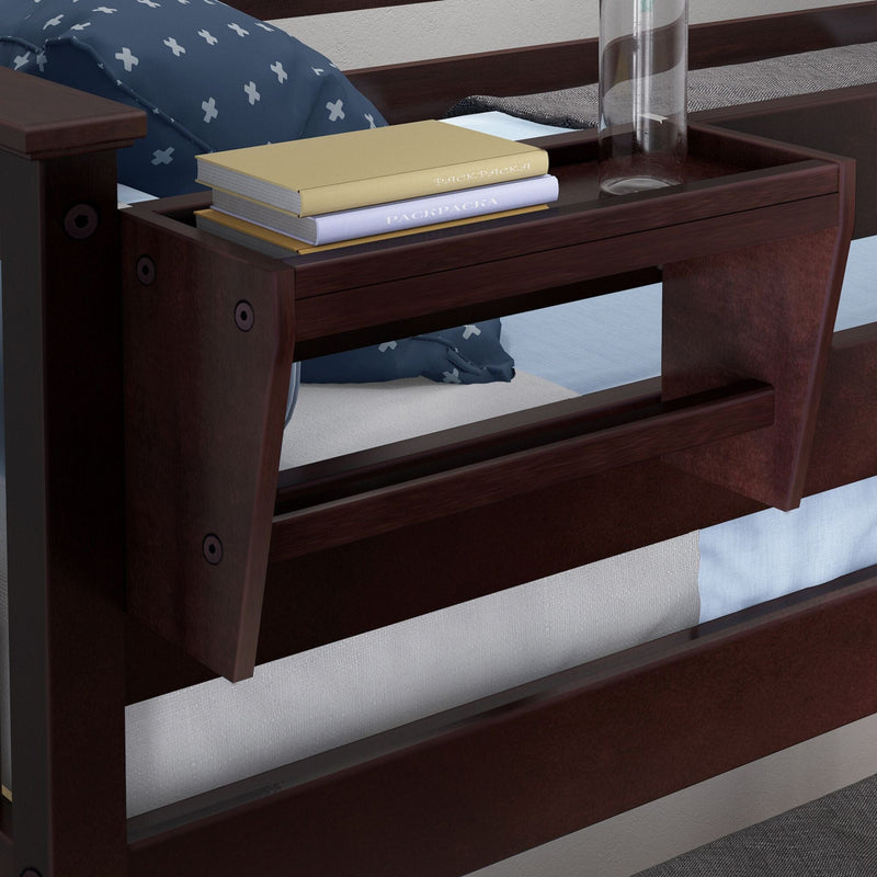 Espresso wooden bunk bed with integrated bedside shelf tray holding stacked books and a glass, blue cross-pattern pillow and light blue bedding