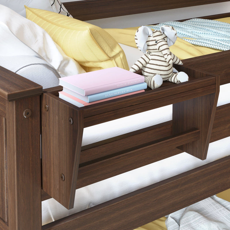 Dark walnut wooden bunk bed side shelf with built-in storage holding a striped elephant plush toy and stacked pastel books, yellow pillow and cozy bedding in a child's bedroom