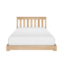 Wooden bed frame with white mattress in a minimalist bedroom setting.