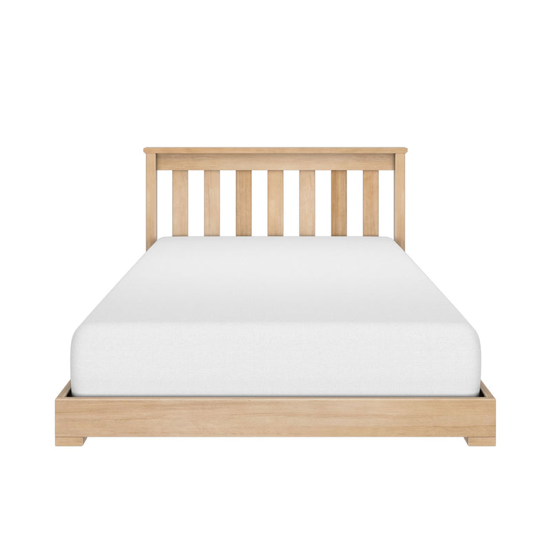 Wooden bed frame with white mattress in a minimalist bedroom setting.