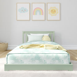 Cozy child's bedroom with pastel-colored bedding and playful wall art featuring cloud, rainbow, and sun illustrations.