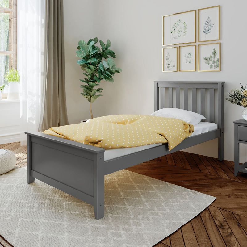 Gray wooden single bed with yellow polka dot bedding in modern bedroom with plant and wall art.