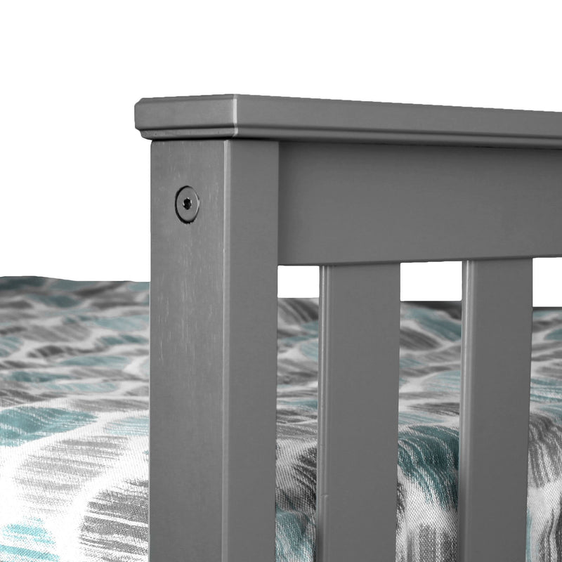 Modern gray metal bed frame detail with patterned teal and gray bedding.