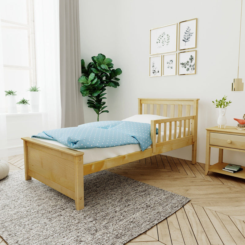 Scandinavian nursery with wooden toddler bed, blue polka-dot bedding, potted indoor plants, botanical framed wall art and natural light