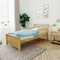 Minimalist kids' bedroom with natural wood bed, blue polka-dot duvet, nightstand, indoor plants and botanical framed prints