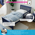 Navy blue wooden kids' bed with safety guardrail installed, blue geometric bedding, potted plant and hardwood floor — easy-to-install bed guardrail and solid pine construction