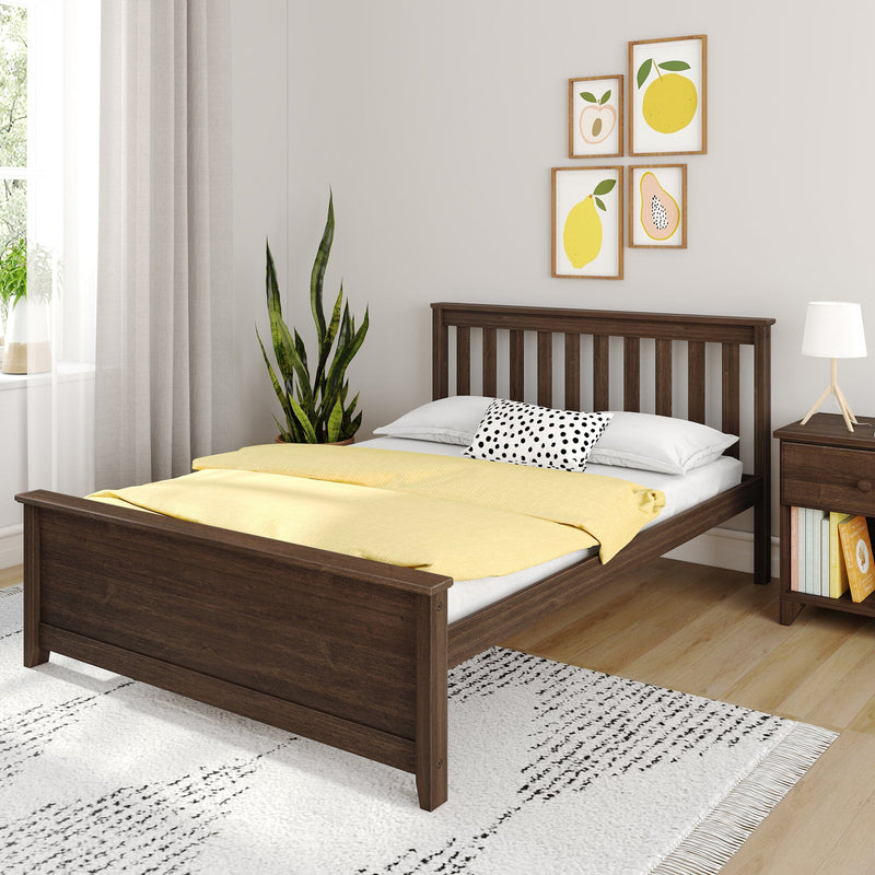 Modern bedroom with dark wood bed frame, yellow duvet, polka-dot pillow, snake plant, fruit wall art and bedside lamp