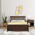 Minimal modern bedroom with dark wood bed, yellow bedding and polka-dot pillow, fruit print gallery wall, wooden nightstand with lamp and potted snake plant