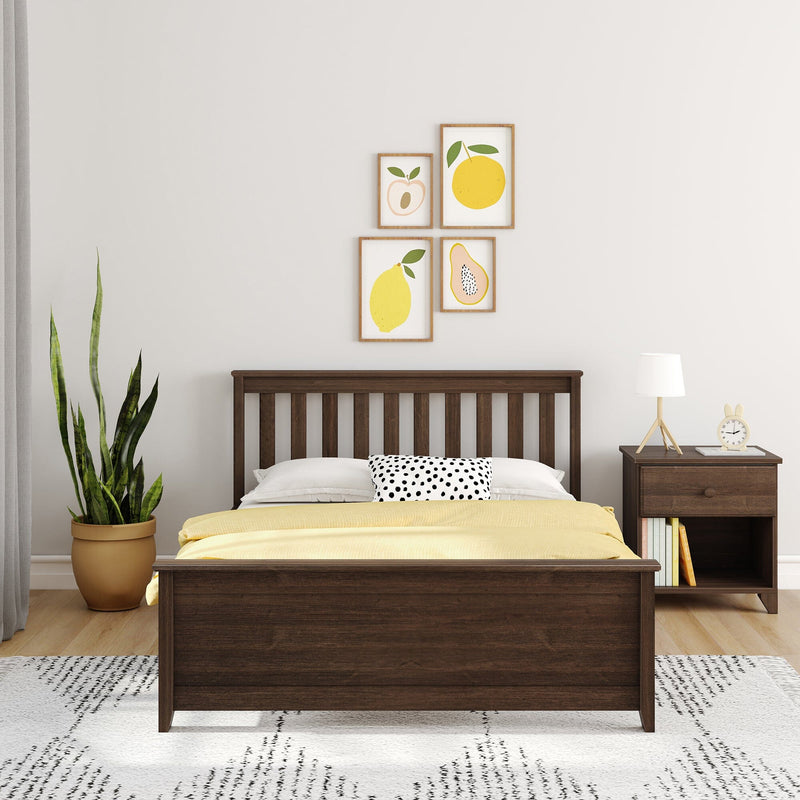 Minimal modern bedroom with dark wood bed, yellow bedding and polka-dot pillow, fruit print gallery wall, wooden nightstand with lamp and potted snake plant