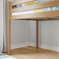 Modern wooden loft bed frame with sturdy legs and slatted guardrail in a bright minimalist bedroom with light hardwood floors, white baseboard trim, gray walls, and yellow and blue bedding