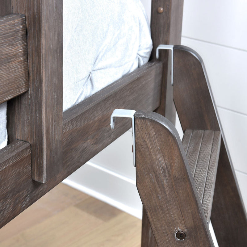 Wooden ladder attached to rustic bunk bed frame with white bedding, showcasing durable design.