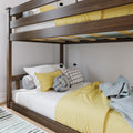 Dark wooden loft-style bunk bed with yellow bedding, decorative pillows and white mattress in a modern kids' bedroom — space-saving design