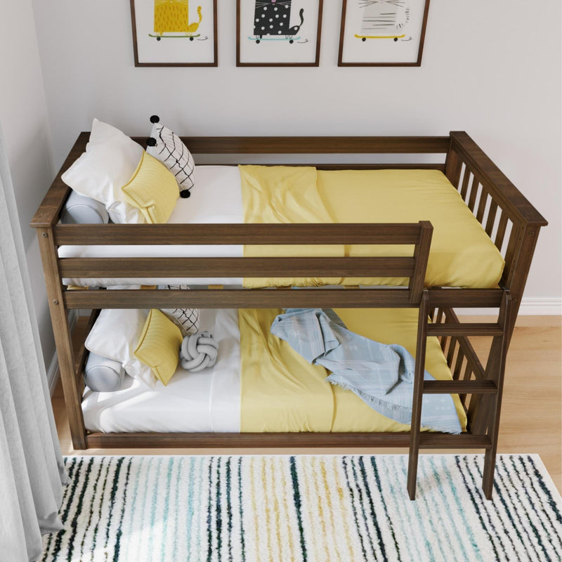 Modern walnut wooden twin-over-twin bunk bed with ladder, yellow bedding and white pillows in a kids' bedroom with framed cat prints and striped rug