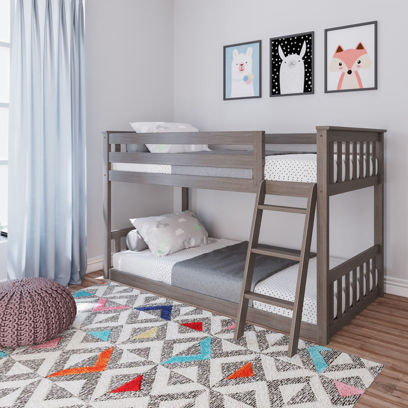 Gray wooden bunk bed with colorful bedding and geometric patterned rug in a bright children's room.