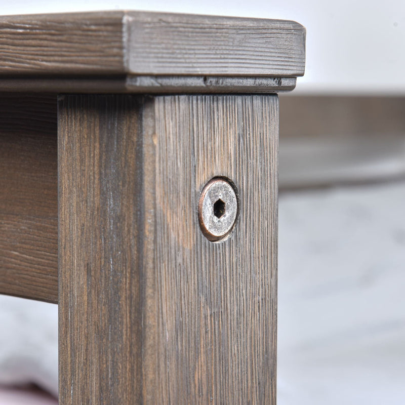 Close-up of gray-stained wooden table leg with exposed hex-socket screw and pronounced wood grain, rustic furniture joinery detail