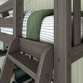 Wooden bunk bed with striped and cross-patterned bedding, featuring a cozy green blanket in a modern bedroom setting.