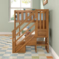 Solid wood kids loft bed with staircase and built-in storage in bright bedroom with mint green walls, blue bedding, window and patterned rug