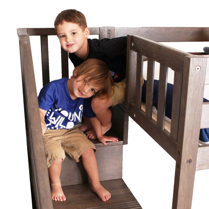 Children playing on wooden bunk bed stairs in a bedroom.