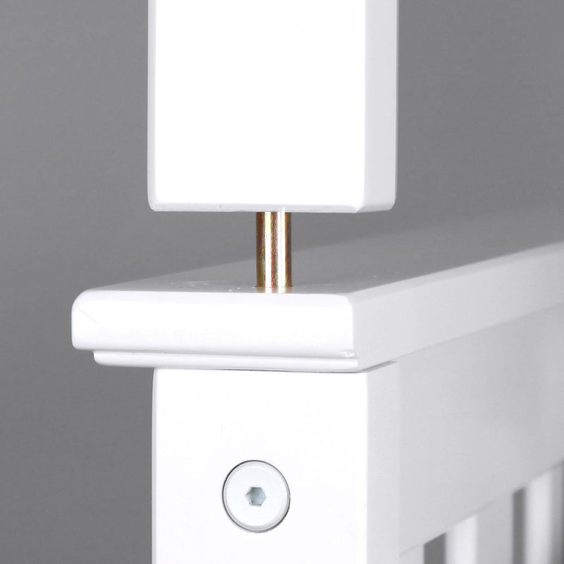 Close-up view of white crib corner joint with screw and wooden dowel connection.