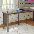 Wooden desk under loft bed in kids' room with colorful cloud wallpaper and natural light from window.
