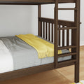 Close-up of dark wood bunk bed ladder and rails with gray knit blanket and yellow throw on mattress in a modern bedroom interior