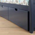 Navy blue wooden platform storage bed with under-bed pull-out drawers and patterned duvet on light hardwood floor