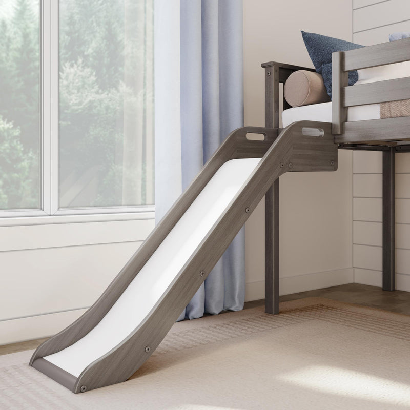 Wooden loft bed with slide and cozy bedding in bright bedroom.