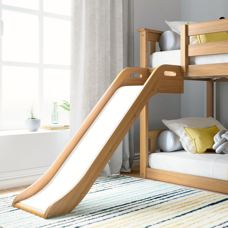 Wooden bunk bed with slide in bright children's room with striped rug.