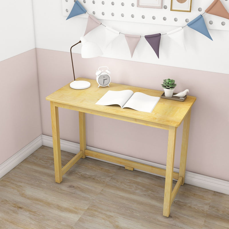Wooden desk with an open book, table lamp, and a small plant, ideal for a minimalist home office setup.