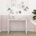 White desk in pastel pink kids' room with bunting and framed rainbow art, desk lamp, succulent, alarm clock and potted plant