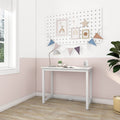 Minimal white writing desk against a pastel pink half-wall nursery with pegboard wall art, rainbow prints, bunting, lamp, succulent and alarm clock